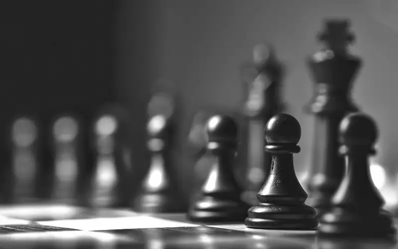 Chess pieces on a board in dramatic light