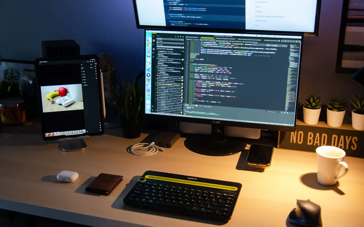 A developer's desk with code on two monitors