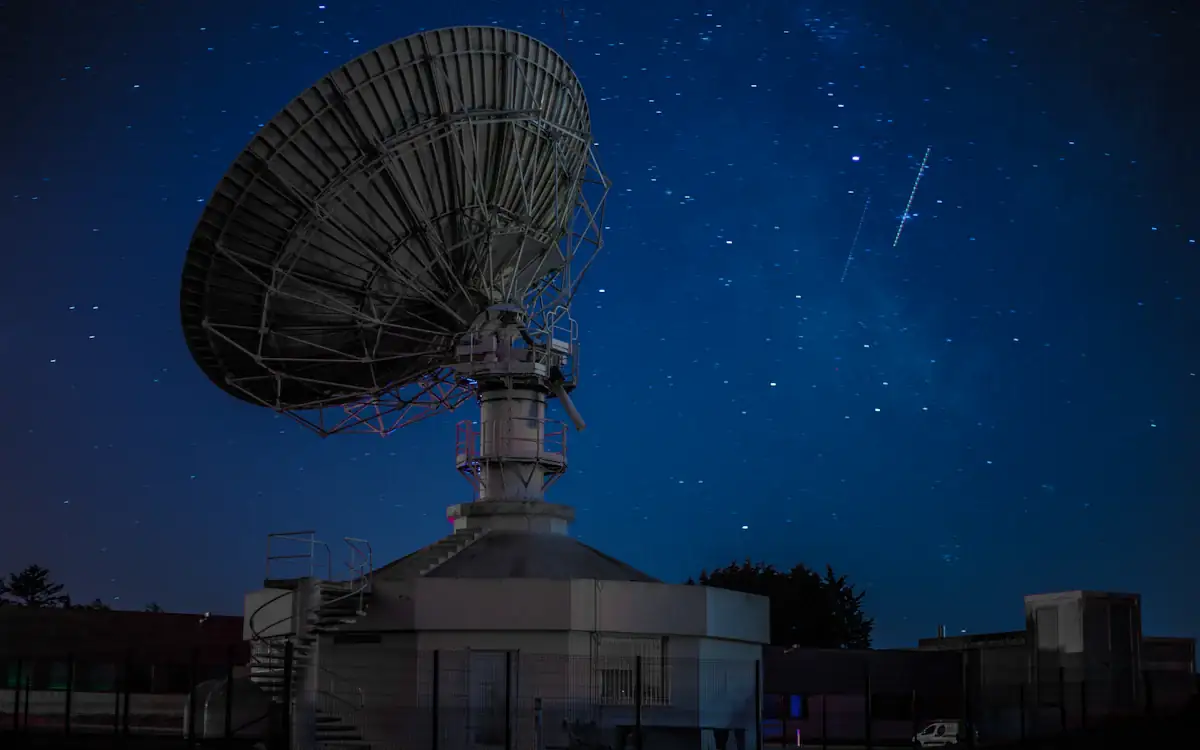 A satellite dish under a starry night sky