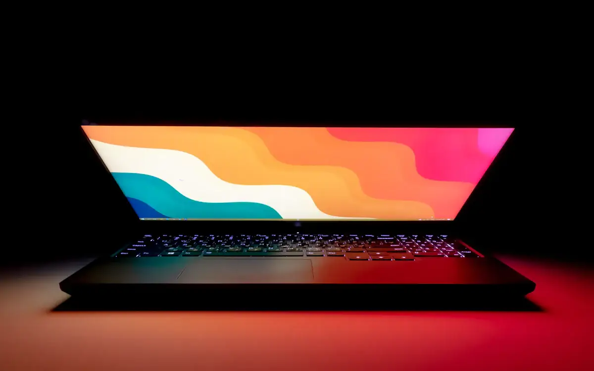 A laptop glowing in a dark room