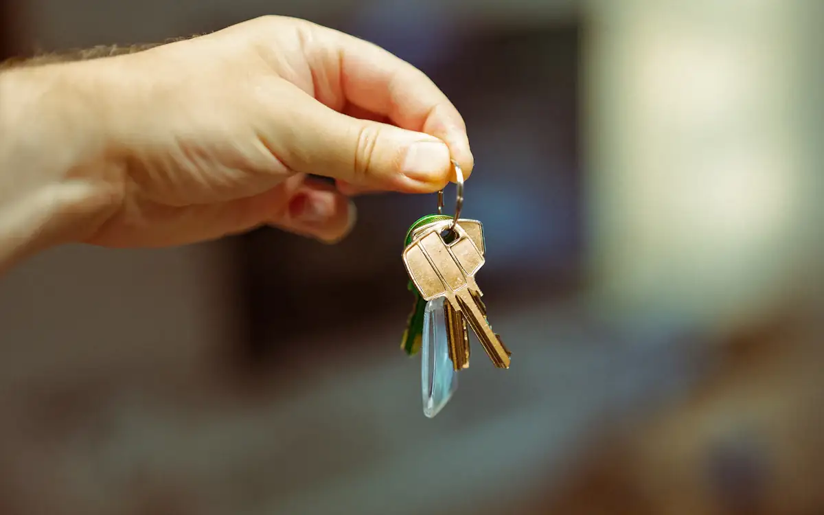 A hand holding out a set of keys